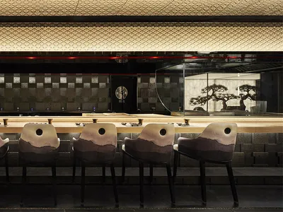 A modern restaurant bar featuring concrete and wooden elements, with a relaxed and sophisticated atmosphere.