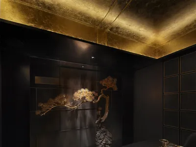 Modern restaurant interior featuring black stone accents and gold lighting fixtures.