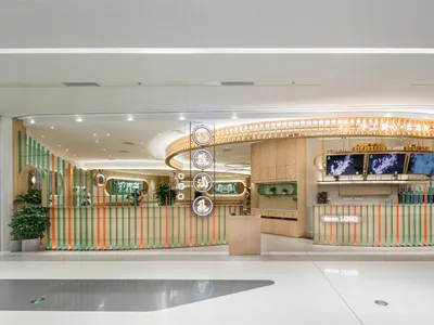 Modern restaurant interior with a wooden counter and colorful accents.