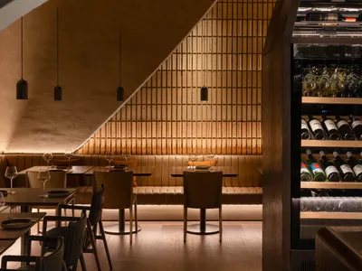 Modern restaurant interior with wooden furniture and concrete walls