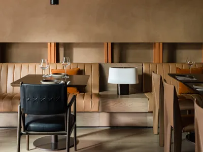 Modern restaurant table with a wooden table and leather chairs.