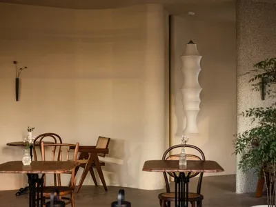 A cozy cafe interior with tables, chairs, and hanging lamp in a minimalist design.