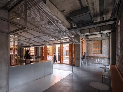 Modern industrial restaurant interior featuring metal, concrete, and brick materials.