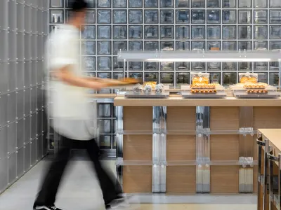 A modern restaurant interior features glass block walls and loft wood accents