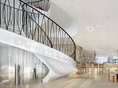 A modern hotel bar with concrete walls and glass elements.