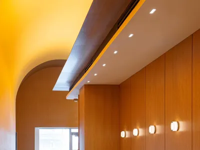 A modern restaurant interior with wooden tables, chairs, and walls.