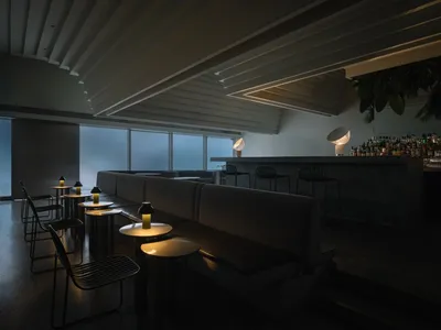 Modern restaurant and bar interior with concrete materials and minimalist design.