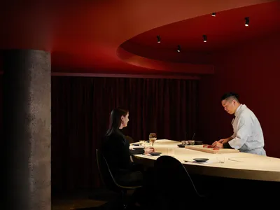 A modern restaurant interior featuring natural wood elements and a minimalist design aesthetic.