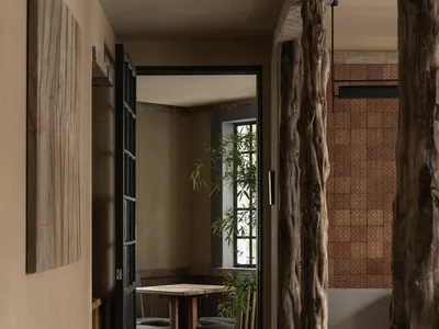 Industrial-themed restaurant interior with wooden tables, concrete flooring, and terracotta tiles.