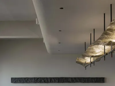 Modern restaurant interior with concrete walls, metal tables, and bar stools
