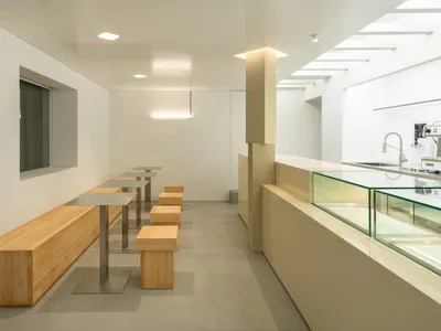 簡約風格的餐廳室內，搭配木製長椅與餐桌。
