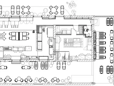 Industrial-style restaurant layout featuring open spaces, large windows, and natural stone finishes.