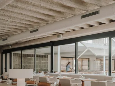 A modern restaurant with a concrete counter featuring minimalist décor and seating areas.