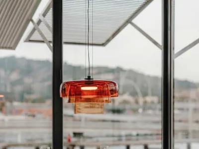 Modern restaurant setting with wooden furniture and orange light fixture.