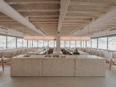 A modern restaurant interior with stone and concrete materials.