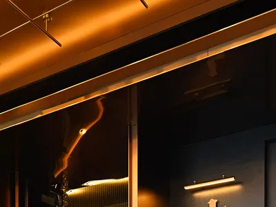 Modern entrance to a restaurant during nighttime with metallic and glass elements