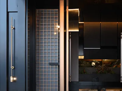 Modern restaurant entryway featuring glass, metal, and stone materials.