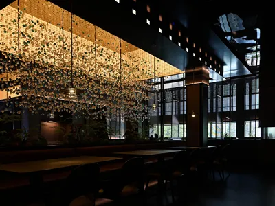 A restaurant interior featuring metallic floating elements hanging from the ceiling.
