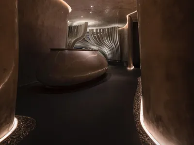 A modern hotel reception area with a polished concrete floor and minimalist design.