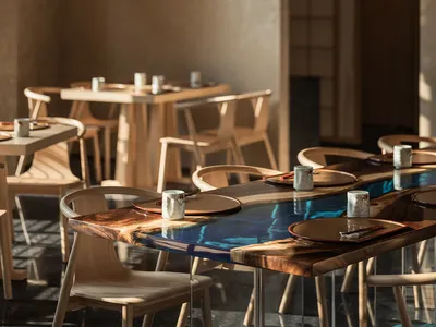 Modern restaurant interior with wooden tables featuring a resin tabletop