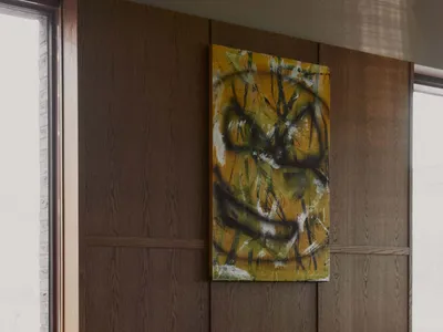 A modern dining room with wooden paneling, a red table, and abstract art on the wall.
