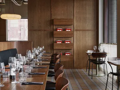 Modern restaurant with wooden tables and chairs, featuring a contemporary design with natural materials.