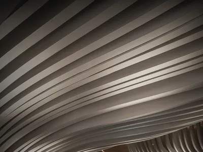 Modern interior design featuring metallic waves and reflected water in a hotel lobby.