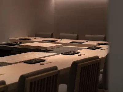 A minimalist restaurant interior featuring wooden furniture and ambient lighting.