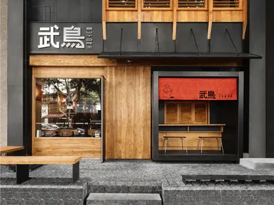 Modern restaurant exterior with black-painted walls and wooden accents.
