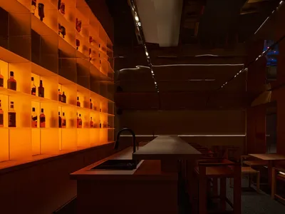 工業風餐廳室內，玻璃層架陳列酒瓶並搭配木質家具