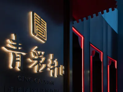 Modern Asian restaurant interior with blue lighting and metallic accents, featuring traditional Chinese characters.