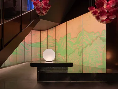 Modern hotel lobby with glass art installations and illuminated globe
