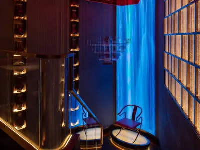 Modern hotel lobby with glass and metal design elements and red and blue lighting