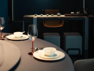 Modern restaurant interior with minimalist design, wooden furniture, and stone accents.