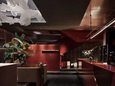 A modern restaurant entrance with red brick walls and metallic accents.