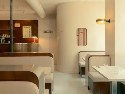 Industrial-style restaurant interior with concrete walls, metal decor, and minimalistic design.