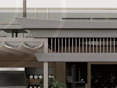 Outdoor seating area of a modern restaurant with concrete floor and glass railings.