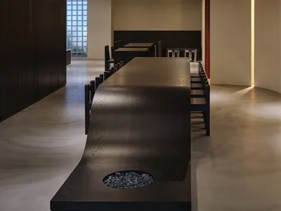 一間現代工業風餐廳，配有深色木質家具與混凝土地板。