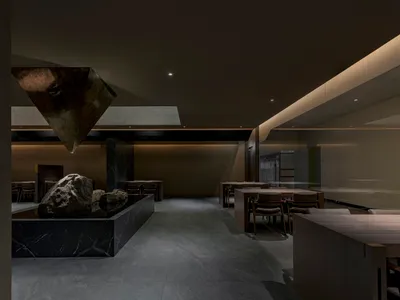 Interior design of a minimalist restaurant featuring marble surfaces and contemporary decor.