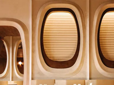 Modern restaurant interior with sleek booth seating and large windows.