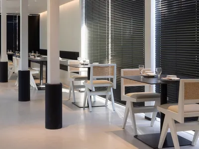 A modern restaurant interior with white furniture and black accents.