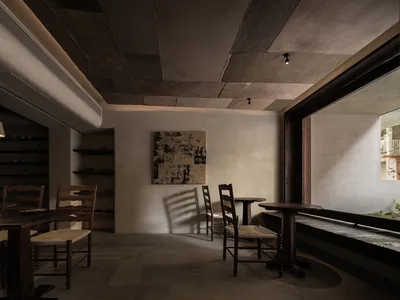 Industrial-style restaurant interior featuring concrete walls and wooden furniture