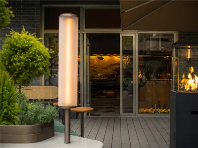 A modern restaurant exterior showcasing glass panels, metal structures, and potted plants.
