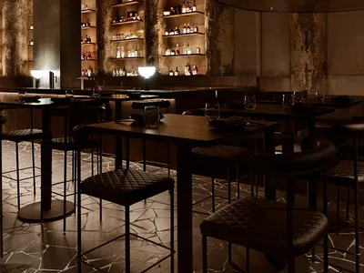 A modern restaurant bar featuring concrete, wood, and glass materials.