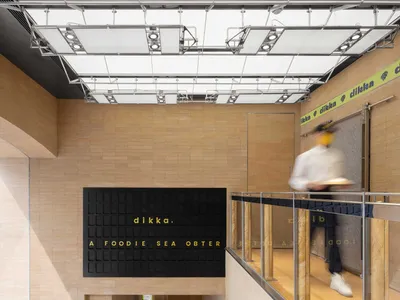 Modern food hall interior with concrete and tile materials, minimalist design.