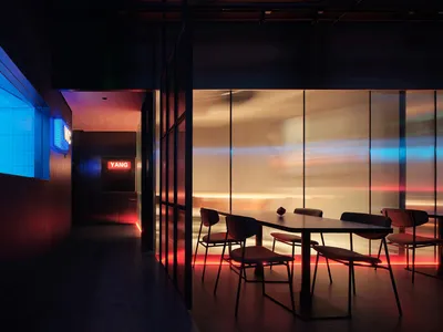 Modern minimalist restaurant featuring glass curtain walls and ambient lighting.
