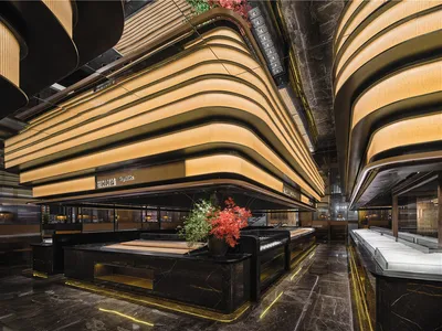 A modern restaurant interior with marble and wood finishes, featuring弧形天花板和明亮的灯光。