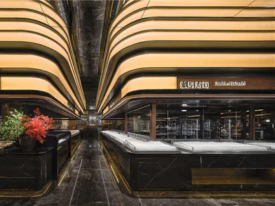 A modern restaurant interior with black marble surfaces and curved lighting fixtures.