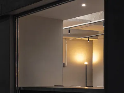 Minimalist restaurant interior with glass walls and warm lighting.