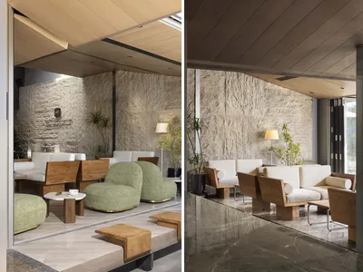 A modern restaurant seating area featuring stone, wood, upholstery, and glass materials.